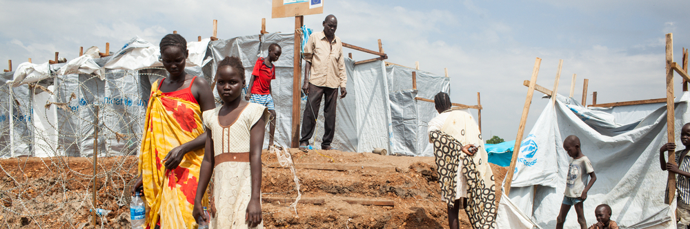 South Sudanese children walk around in a refugee camp